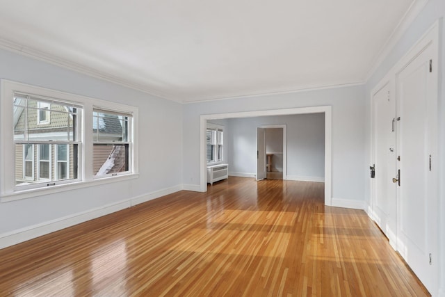 unfurnished room with crown molding, radiator, and light hardwood / wood-style floors