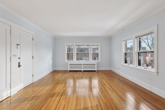 unfurnished room featuring radiator, ornamental molding, a healthy amount of sunlight, and light wood-type flooring