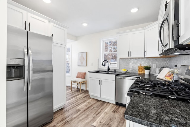 kitchen featuring dark stone countertops, sink, stainless steel appliances, and white cabinets