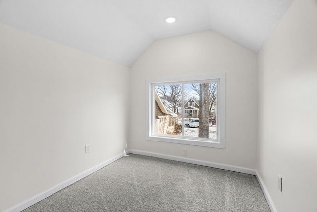 unfurnished room featuring lofted ceiling and carpet flooring