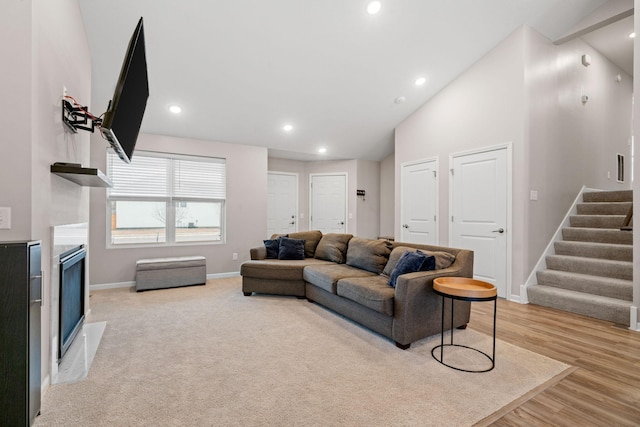 living room with high vaulted ceiling and light wood-type flooring