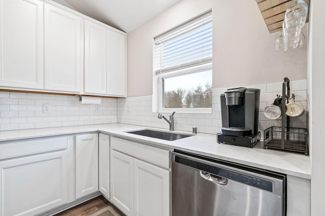 kitchen featuring sink, white cabinetry, light stone counters, decorative backsplash, and stainless steel dishwasher