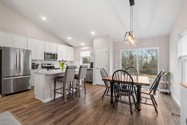 dining area with lofted ceiling and dark hardwood / wood-style flooring