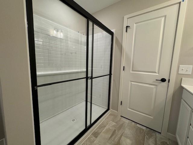 bathroom with vanity and a shower with door