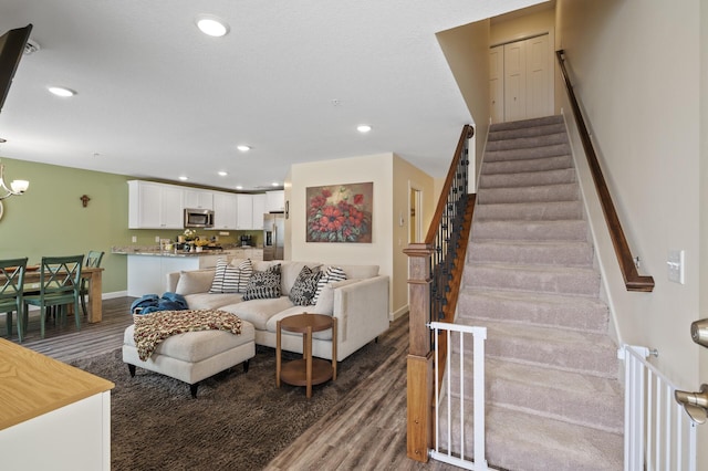 living room with dark wood-type flooring and a notable chandelier