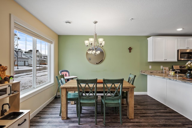 dining area featuring dark hardwood / wood-style flooring, a chandelier, and sink