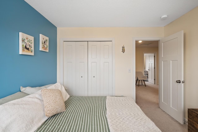 bedroom featuring light carpet and a closet