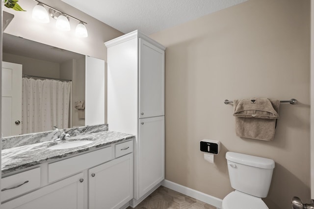 bathroom with vanity, a textured ceiling, parquet flooring, and toilet