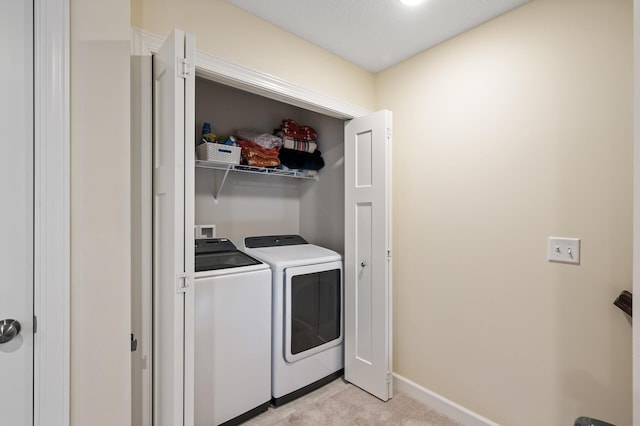 laundry area featuring light colored carpet and separate washer and dryer