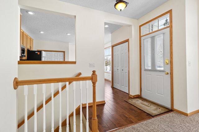 foyer with dark wood-type flooring and a textured ceiling