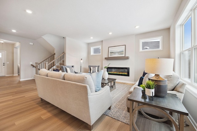 living area featuring recessed lighting, stairs, and light wood-style flooring