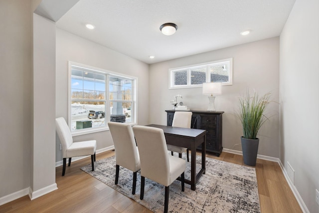 dining space with baseboards, visible vents, and light wood-style floors