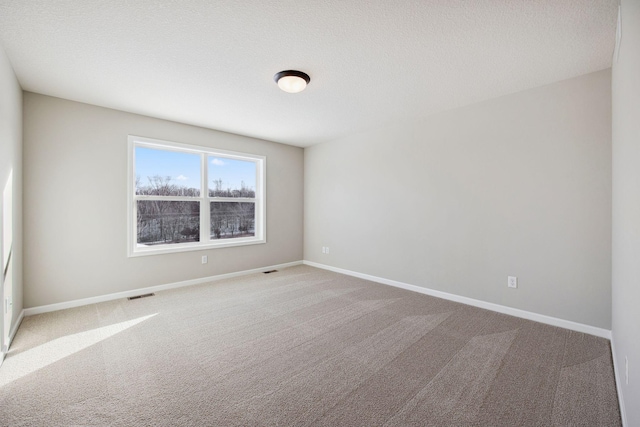 unfurnished room featuring baseboards, carpet flooring, and visible vents