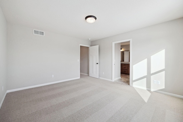 unfurnished bedroom with visible vents, baseboards, and light colored carpet
