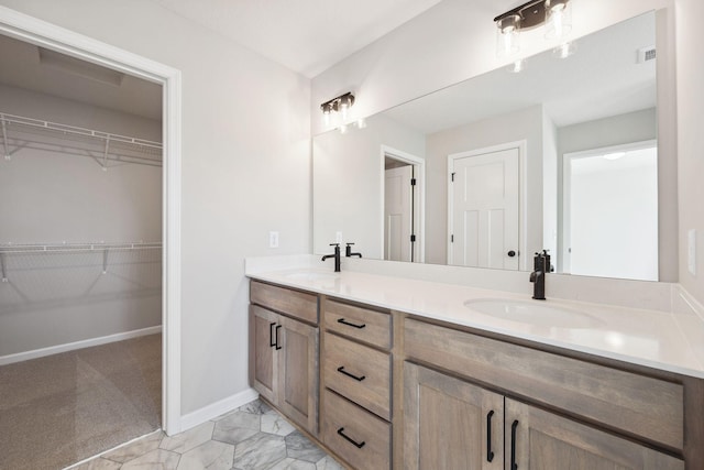 full bath with a sink, a spacious closet, double vanity, and visible vents