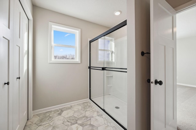 bathroom featuring baseboards and a stall shower