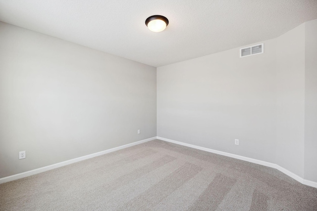 unfurnished room featuring visible vents, carpet, and baseboards