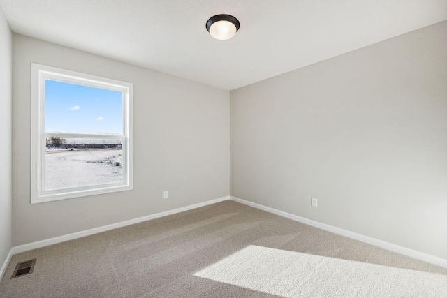 empty room featuring baseboards, visible vents, and carpet