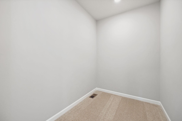 unfurnished room with baseboards, visible vents, and light carpet