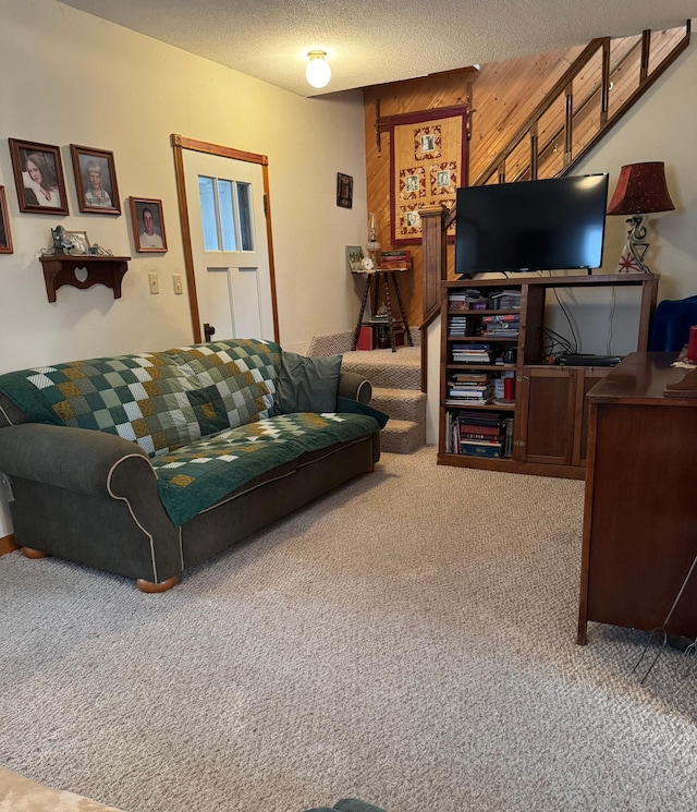 living room with wooden walls, carpet flooring, and a textured ceiling