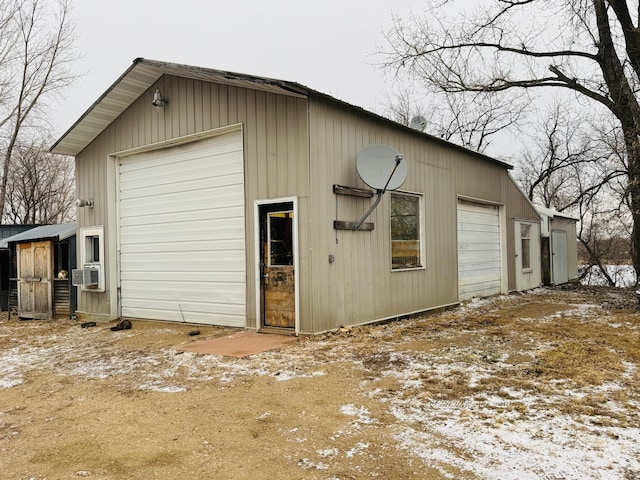 snow covered garage featuring cooling unit