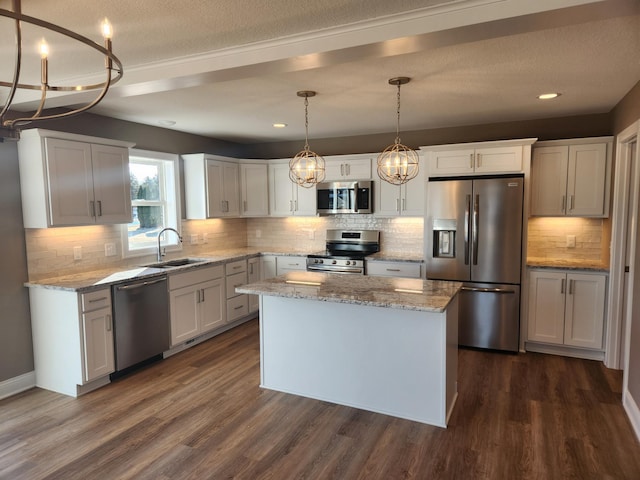 kitchen with sink, decorative light fixtures, a center island, stainless steel appliances, and white cabinets