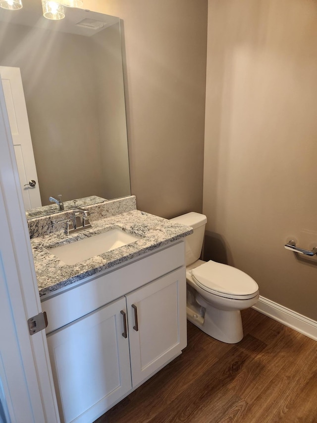 bathroom with vanity, hardwood / wood-style flooring, and toilet