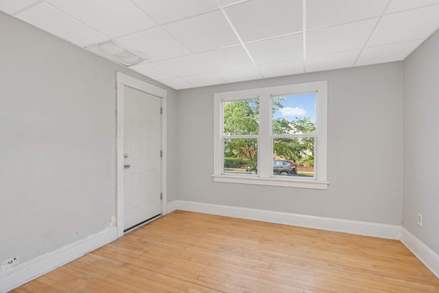 empty room with a paneled ceiling and light hardwood / wood-style floors