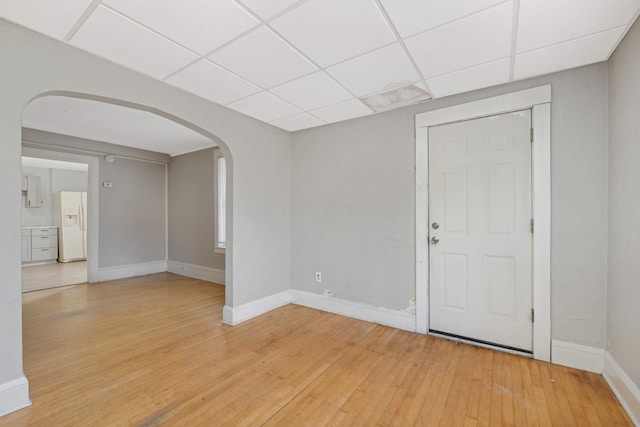 spare room featuring light hardwood / wood-style floors and a drop ceiling