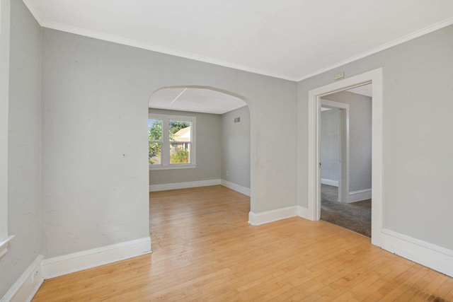 empty room with ornamental molding and light hardwood / wood-style floors