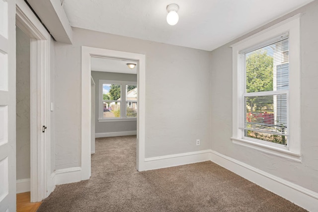 unfurnished room featuring light carpet