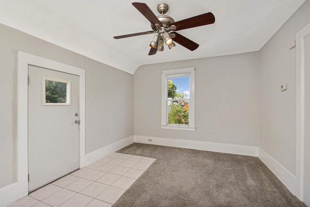 empty room featuring lofted ceiling, light carpet, and ceiling fan