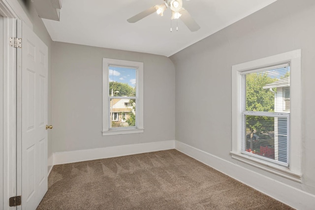 carpeted empty room with ceiling fan and lofted ceiling