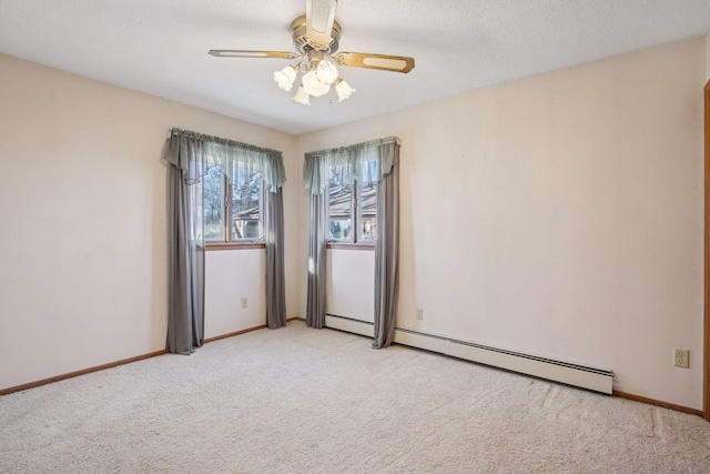 empty room with ceiling fan, a baseboard radiator, light colored carpet, and a textured ceiling