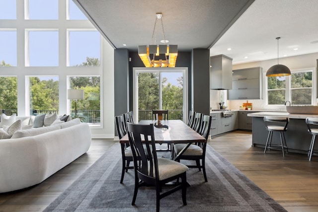 dining space with an inviting chandelier, dark hardwood / wood-style floors, and a textured ceiling