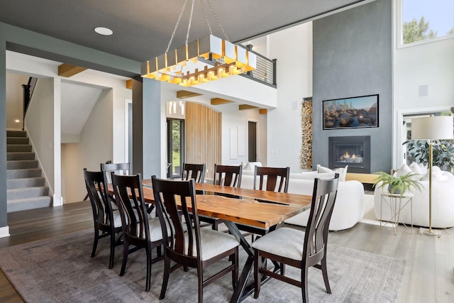 dining space with a towering ceiling and dark hardwood / wood-style flooring