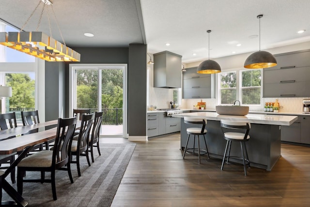 kitchen with decorative light fixtures, gray cabinets, and a kitchen island