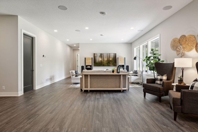 living room with dark wood-type flooring and a textured ceiling