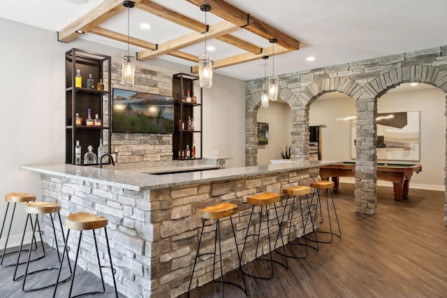 bar featuring light stone countertops, coffered ceiling, pendant lighting, and dark hardwood / wood-style flooring