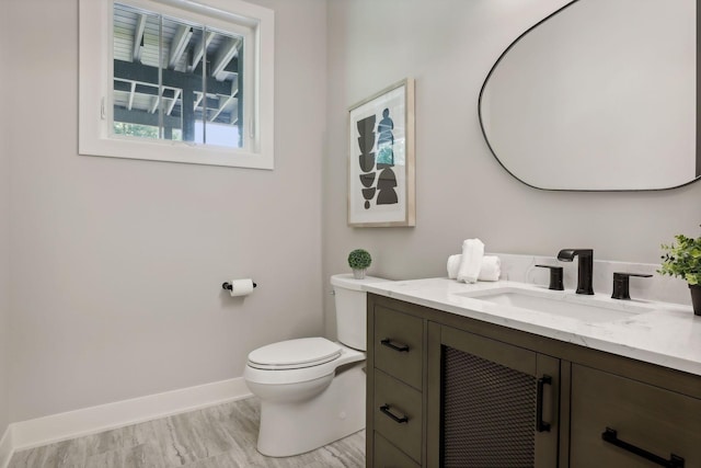 bathroom with hardwood / wood-style flooring, vanity, and toilet