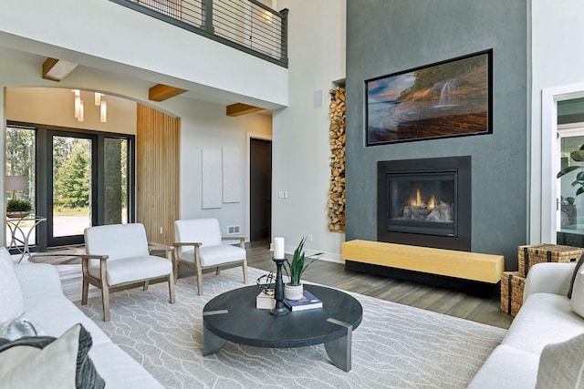 9533 Otchipwe Ave N, Stillwater, MN 55082 - living area with a fireplace, baseboards, wood finished floors, a towering ceiling, and visible vents