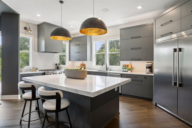 9533 Otchipwe Ave N, Stillwater, MN 55082 - kitchen featuring gray cabinets, decorative backsplash, appliances with stainless steel finishes, a sink, and wall chimney exhaust hood