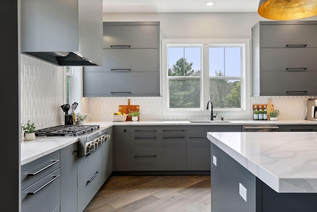 9533 Otchipwe Ave N, Stillwater, MN 55082 - kitchen featuring decorative backsplash, gray cabinets, wall chimney exhaust hood, a sink, and stainless steel appliances