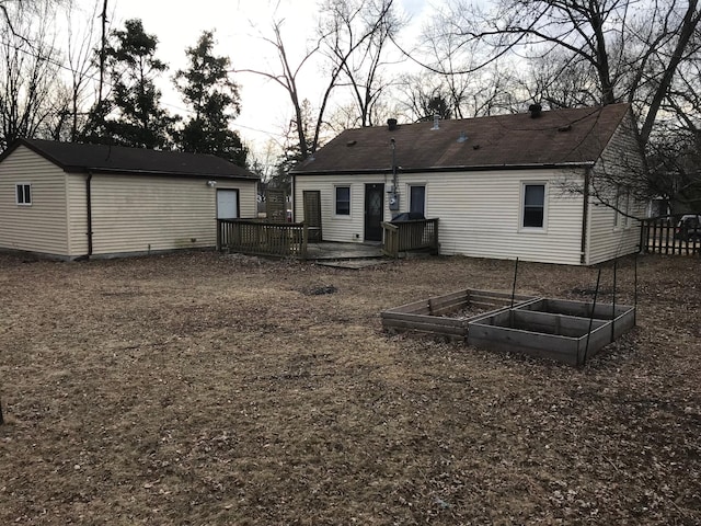 rear view of property featuring a wooden deck and an outbuilding