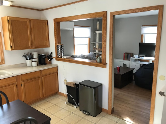 kitchen with a wall mounted air conditioner and ornamental molding