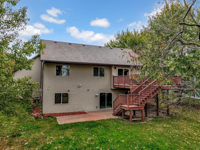 rear view of house featuring a wooden deck, a patio area, and a lawn