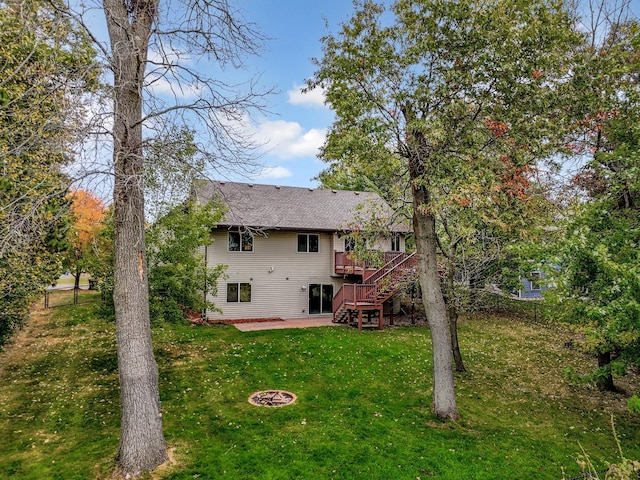 back of property with a wooden deck, a yard, and a patio area