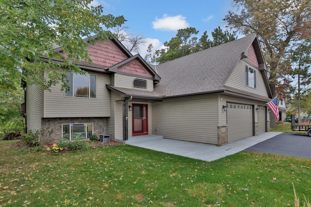 craftsman inspired home with a garage, central AC unit, and a front lawn