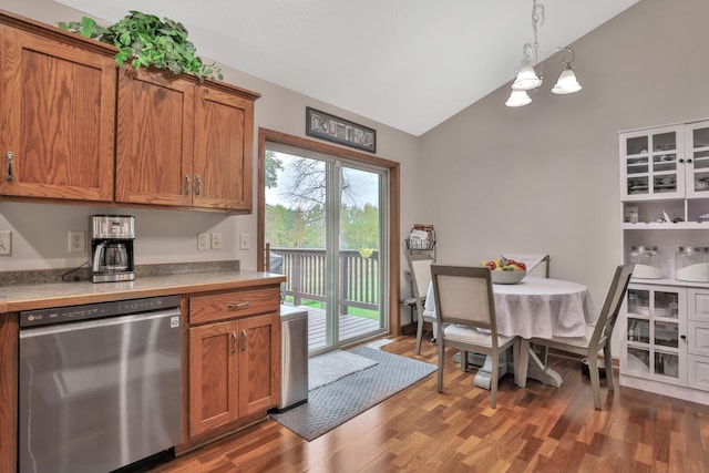 kitchen with pendant lighting, lofted ceiling, dark wood-type flooring, an inviting chandelier, and stainless steel dishwasher