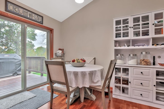 dining space featuring lofted ceiling and dark hardwood / wood-style flooring